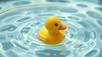 Yellow rubber duck floating peacefully on clear water creating ripples in a calm environment photo