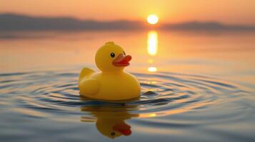 Yellow rubber duck floats on calm water at sunset, creating a serene and peaceful atmosphere photo