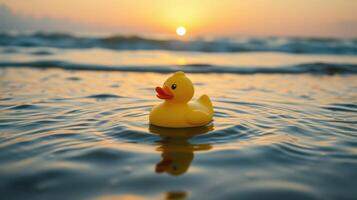 Yellow rubber duck floats serenely in ocean waves during sunset near the shoreline photo