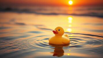 Yellow rubber duck floating on calm water during sunset at the beach creating a serene atmosphere photo