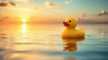 Bright yellow rubber duck floats serenely on calm water during vibrant sunset with colorful sky photo