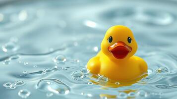 Bright yellow rubber duck floating in clear water with gentle waves photo
