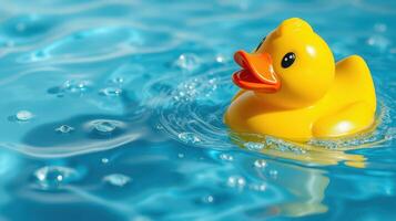 Yellow rubber duck floating in clear water on a sunny day creating playful ripples photo