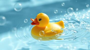 Bright yellow rubber duck floats in a pool surrounded by splashes and bubbles on a sunny day photo