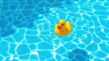 Bright yellow rubber duck floats peacefully in clear blue swimming pool water on a sunny afternoon photo