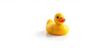 Bright yellow rubber duck floats on a smooth surface during playful bath time photo