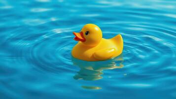 Bright yellow rubber duck floats gently on the surface of a clear blue pool during a sunny day photo