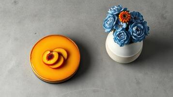 Beautiful dessert with fresh peach slices beside decorative flower arrangement on gray surface photo