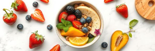 Colorful fruit bowl with fresh ingredients, nuts, and garnishes on a marble countertop photo