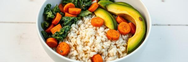 Nutritious grain bowl with vegetables and avocado served in a white bowl photo