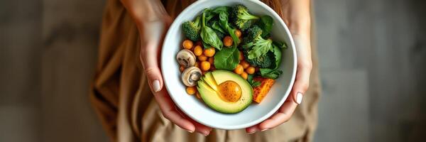 Healthy bowl of mixed vegetables and chickpeas held by a person in a cozy indoor setting photo