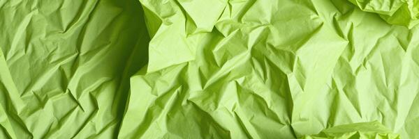 Crumpled green paper creates an abstract background texture for creative projects and graphic design photo