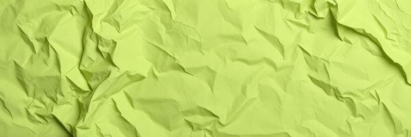 Textured crumpled green paper background for creative design and crafts photo