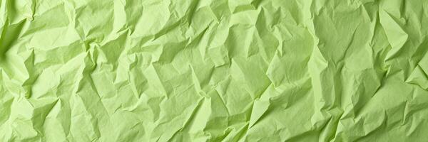Green crinkled paper creates a textured background suitable for artistic projects and design work photo