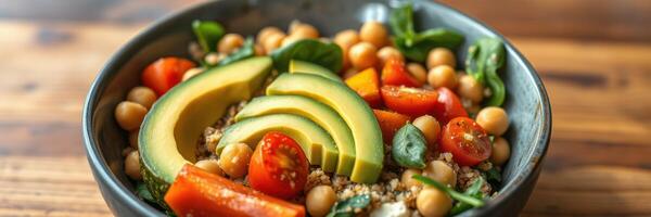 Healthy bowl with chickpeas, avocado, cherry tomatoes, and fresh vegetables served in a rustic setting photo