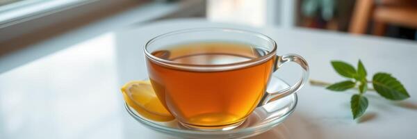 Warm cup of tea with lemon slice placed on a white table in a cozy cafe setting photo