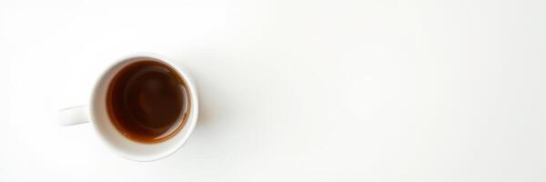 Enjoying a warm cup of coffee on a clean white table in the morning sun photo