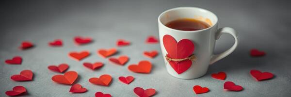 Hot beverage in charming mug surrounded by small red heart shapes on a gray surface creating a romantic atmosphere photo
