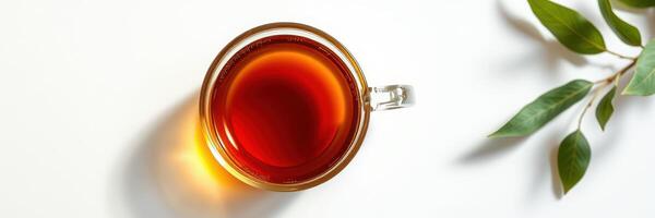 Warm cup of herbal tea on a light surface with green leaves enhancing a calm atmosphere photo