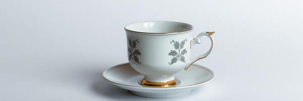 Elegant porcelain tea cup on saucer with intricate design placed on a light background photo