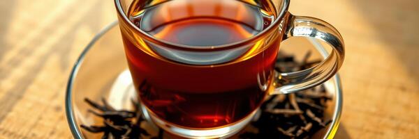 Warm cup of brewed tea served with fresh tea leaves on a wooden table in a cozy setting during the afternoon photo
