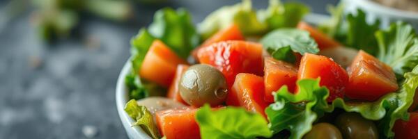 Fresh salad with tomatoes and olives served in a bowl on a dark table photo
