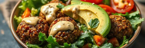 Delicious falafel bowl with fresh vegetables and creamy sauce served on a wooden table photo
