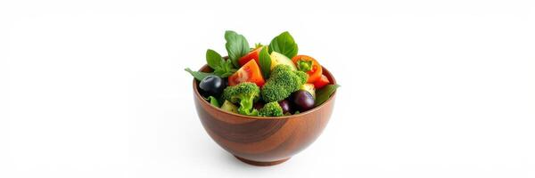 Fresh vegetable salad featuring broccoli, tomatoes, olives, and mixed greens in a wooden bowl on a white background photo
