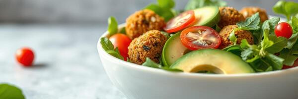 Fresh vegetable salad with falafel balls garnished with cherry tomatoes and cucumber slices photo