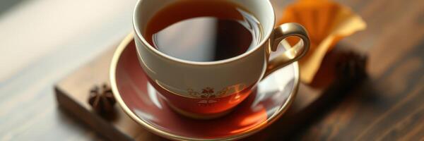 Warm cup of tea served on wooden table with delicate treats during afternoon relaxation photo