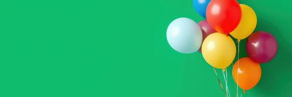 Colorful balloons arranged against a bright green background for a festive celebration or party photo
