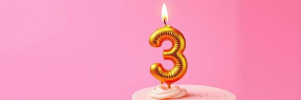 Celebration of a third birthday with a golden number three candle atop a cake against a pink background photo