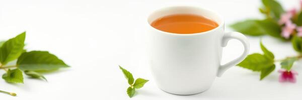 Warm herbal tea in a white cup surrounded by fresh leaves and flowers on a bright background photo