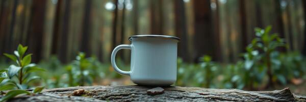 Warm beverage sits on log in serene forest setting surrounded by greenery during early morning light photo