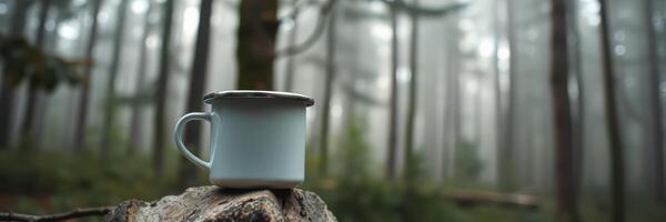 Cozy camping mug rests on a log in a misty forest at dawn, surrounded by tall trees and soft light photo
