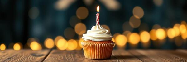 Celebrate a special occasion with a cupcake topped with a candle amidst a beautiful blur of festive lights photo