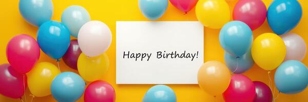 Colorful balloons surround a cheerful birthday greeting against a bright yellow background photo