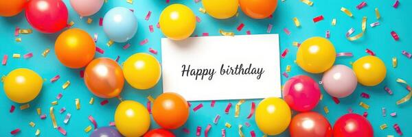 Colorful birthday decorations with balloons and a card on a bright blue background photo