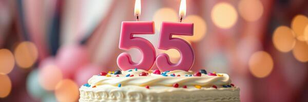 Celebration of a special 55th birthday with a decorated cake and lit candles at a festive gathering photo