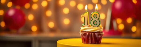 Cupcake topped with two candles celebrating an 18th birthday at a festive party photo