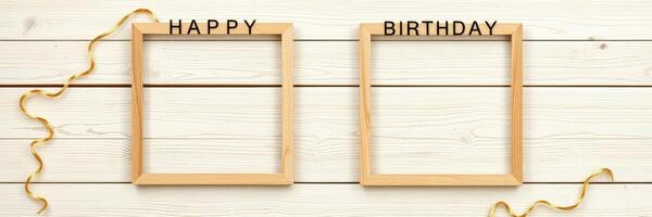 Decorative wooden frames with happy birthday text and golden ribbons for celebrations photo