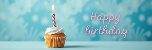 Celebration of a birthday with a festive cupcake adorned with a candle on a blue background photo
