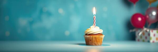 Celebration with cupcake featuring a candle on a festive background with balloons and gifts photo