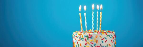 Colorful birthday cake with candles against a blue background celebrating a joyful occasion photo