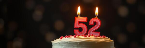 Celebratory cake with 52 candles lit during a birthday party at a festive gathering photo