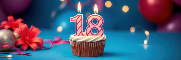 Celebration of an 18th birthday with a festive cupcake, candles, and colorful decorations in a decorated venue photo
