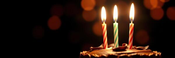 Celebrate a joyful birthday with a chocolate cake adorned with three lit candles casting a warm glow photo