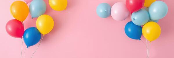 Colorful balloons in various shades floating against a pink background for a festive celebration photo