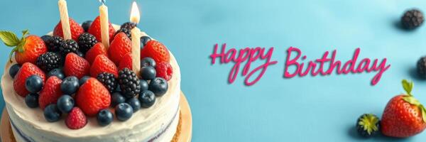 Colorful birthday cake topped with fresh fruits and candles set against a blue background with a birthday greeting photo