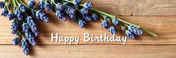 Birthday wishes conveyed through blue flowers on a rustic wooden surface photo